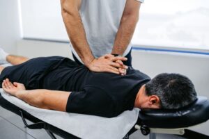 Chiropractor adjusting client’s upper spine